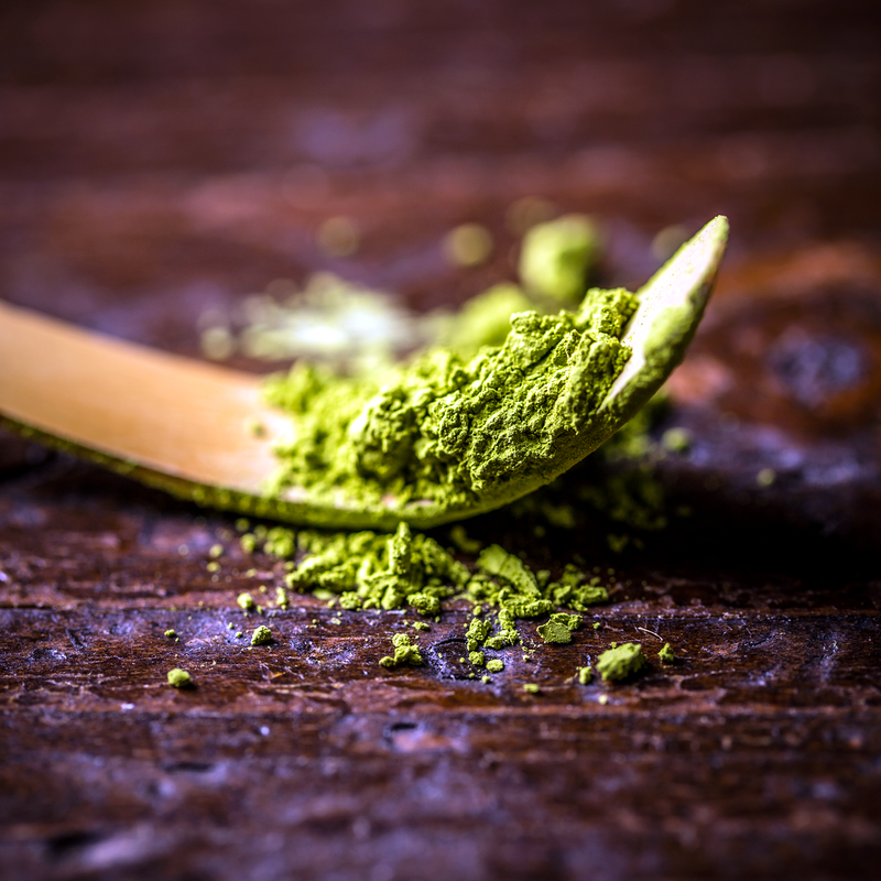 Green ingredient powder on a wooden spoon